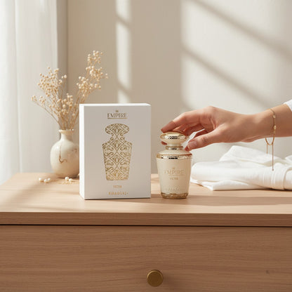 Oud Sera Khadlaj Empire Victor perfume bottle and white gift box with gold ornate detailing on a wooden table.